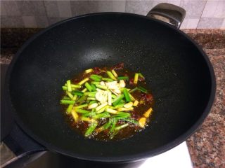 胡萝卜炒牛肉丝,放入蒜苗头和大蒜片翻炒10秒。