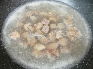 土豆烧牛肉,锅内放水，加一勺料酒烧开，下入牛肉焯水，再次烧开以后关火。