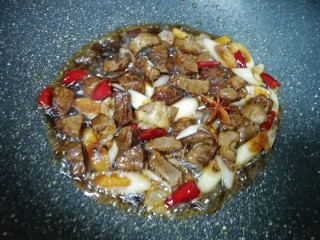 土豆烧牛肉,加入两勺红烧酱油和一勺料酒翻炒均匀。