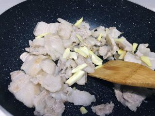 下饭菜之青椒炒肉片,将大蒜洗净拍松切小块放入锅中