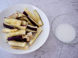 鱼香茄条,把腌制好的茄条用手挤干水分，碗中加入1勺淀粉加入少量水调成水淀粉备用