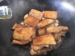 红烧带鱼,倒入2勺料酒。