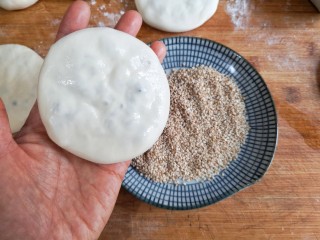 梅干菜肉烧饼,将包好的饼坯按扁，一面薄薄刷一层清水。