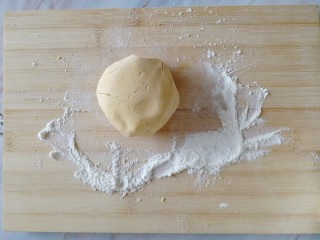 南瓜糯米夹心饼,案板上撒一层面粉，捏一小坨面出来