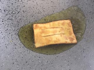 煎饼果子,热锅倒油，下入面皮，炸制金黄