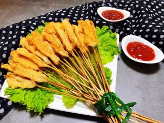 鸡肉串串香,盘中摆上生菜再把鸡肉串串用韭菜捆起来摆在盘中搭配番茄酱和蒜蓉辣椒酱