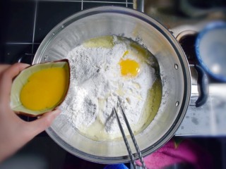 奶香葡萄干小面包（电饭锅版）,打入一个全蛋，另一个鸡蛋将蛋白与蛋黄分离，只打入蛋白，蛋黄用小容器装着，备用。