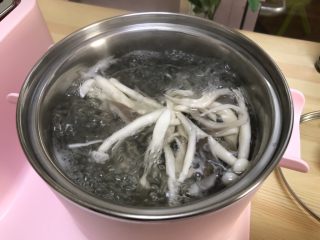 三鲜菌菇汤,早餐机煮锅加入清水烧开焯水平菇和海鲜菇3分钟捞出沥干。