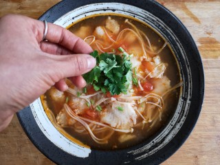 金针菇番茄龙利鱼,上桌前点缀适量香菜，金针菇番茄龙利鱼锅完成！