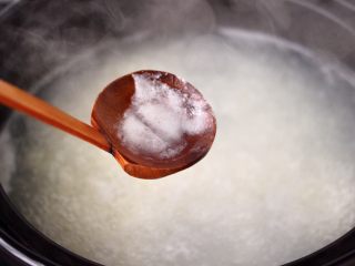 螃蟹青菜辣椒粥,用勺子撇去表面浮末。