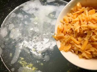 干贝苦瓜羹,把干贝水和干贝一起倒入锅里，大火把汤煮开，加入适量盐调匀。