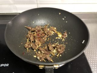 孜然牙签牛肉,倒入孜然粉，孜然粒，辣椒粉翻炒均匀即可