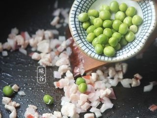 椰子海鲜芝士焗饭,青豆用开水煮一分钟捞起,倒入锅内翻炒;