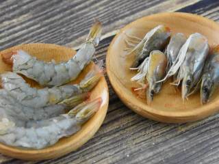 酸酸甜甜超级美味的海鲜菠萝饭，炎热夏季也能让你食欲大增,菠萝切小块，取出盐水浸泡。虾头身分离，虾身部分去壳，备用。