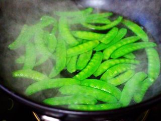 荷兰豆海鲜豆芽小炒,炒锅里倒入适量清水煮沸后，加入一勺盐，把洗净的荷兰豆焯水至变色，捞出后用冷水浸泡备用。